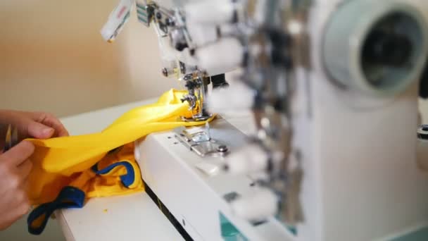 Haciendo ropa. La mujer trabaja en la máquina de coser. Enfoque en tela — Vídeos de Stock