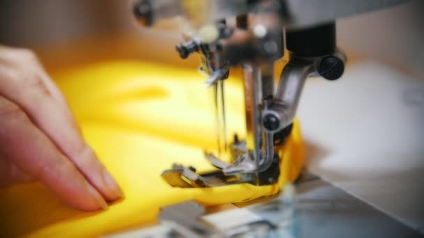 Haciendo ropa. Las manos femeninas trabajan en la máquina de coser en el estudio. Disparo en cámara lenta — Vídeo de stock