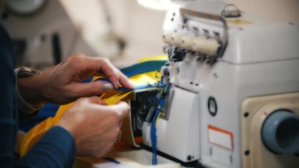 Haciendo ropa. Las manos femeninas trabajan en la máquina de coser en el estudio. Primer plano. — Vídeos de Stock