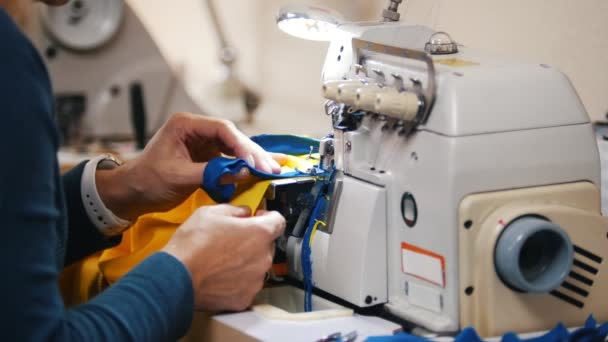 Haciendo ropa. Las manos femeninas trabajan en la máquina de coser en el estudio . — Vídeos de Stock