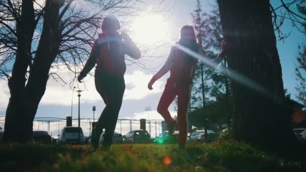 Two young woman in sport costumes are warming up in park — 图库视频影像