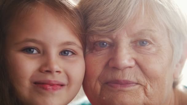 Закрыть портрет бабушки и внучки. Голубые глаза. Разница в возрасте — стоковое видео