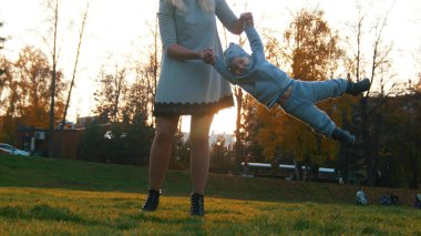 Genç Anne onu elele tarafından küçük bebeğini yukarı atar