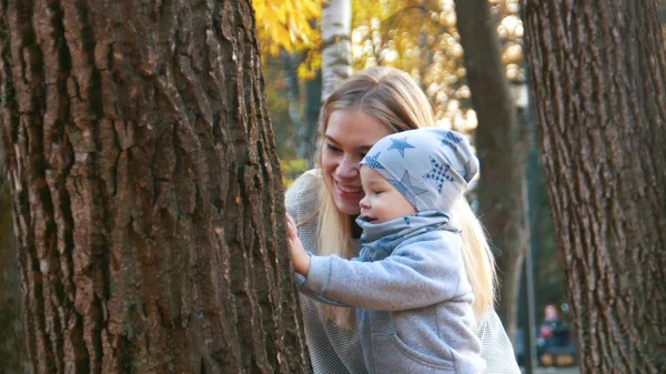 Ung mamma och hennes lilla bebis tittar på trädet — Stockfoto