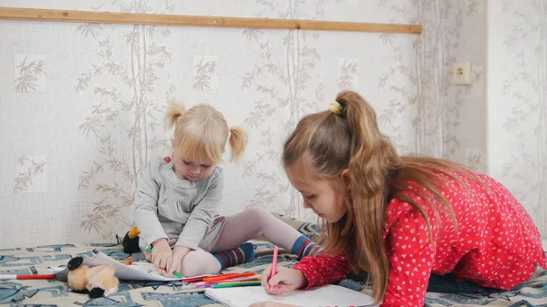 Due bambini caucasici seduti sul letto a disegnare — Foto Stock