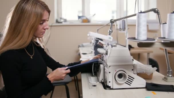 Young woman working with sewing machine on factory — Stock Video