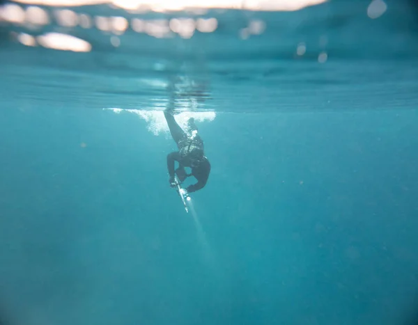 Spearfishing man with flashlight at the top of lake — Stock Photo, Image