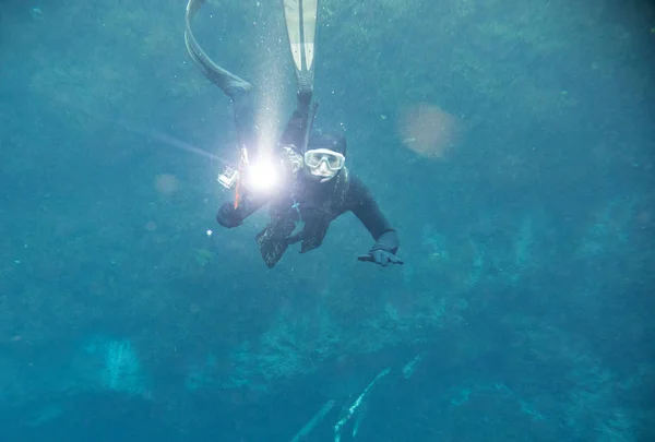 Spearfishing man with flashlight in deep of lake looking to the camera — Stock Photo, Image