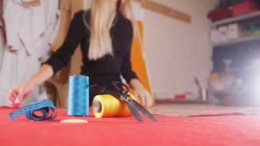 Genç kadın dikiş fabrikası bez bir makasla kesme. Dikiş ipliği odak. Atış statik