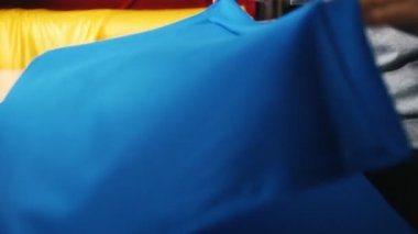 Mavi bir bez masanın üzerine koyarak giyim fabrikası'nda çalışan