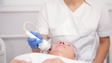 Anti-aging yordamı. Araç ile çalışma. Yüz yumuşatma. Yakın çekim. Düşük açılı