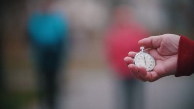 Bir cep saati tutan bir yaşlı kadın. Eldery kadının yürüyüş üzerinde odaklanın. Ağır çekim