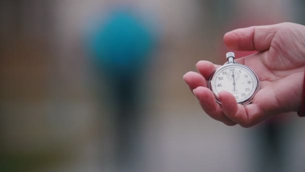 Una anciana sosteniendo un reloj de bolsillo, inicia el temporizador. Céntrate en la mujer mayor disfrutando del senderismo — Vídeo de stock