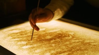 Bir kum ile ekranda çizim. Anime kedi, karikatür örümcek. Eller