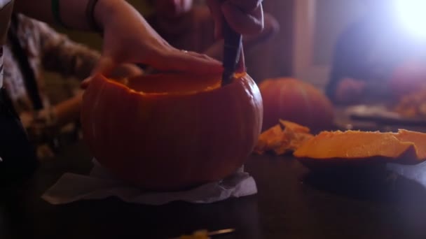 Halloween-Party. eine Gruppe von Leuten schneidet den Kürbis — Stockvideo