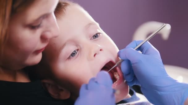 Οδοντιατρική. Ο οδοντίατρος εξετάζει τη στοματική κοιλότητα του παιδιού. — Αρχείο Βίντεο