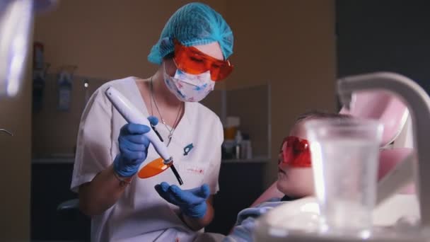 Οδοντιατρική, ιατρική. Ο οδοντίατρος εργάζεται με τη λυχνία — Αρχείο Βίντεο