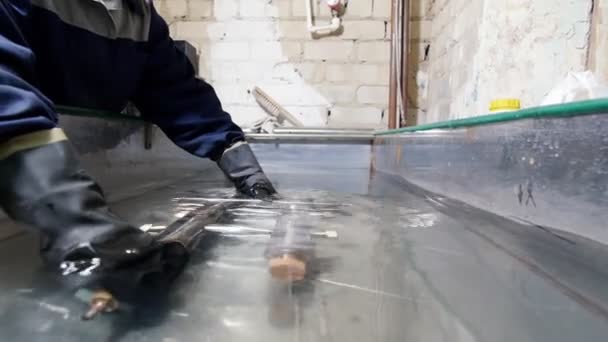 Industriefabrik. Arbeiter legt Rohre ins Wasser — Stockvideo