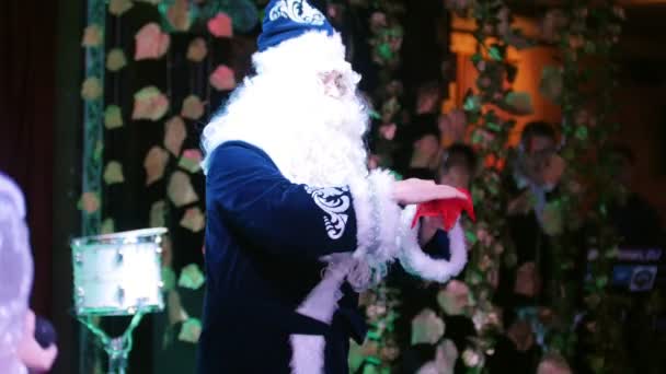 Firmenparty. Weihnachtsmann im blauen Kostüm zeigt einen Trick. Väterchen Frost. — Stockvideo