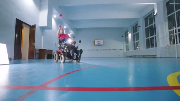 坐在轮椅上的残疾人 把一个红色的小球抛向空中 慢动作 — 图库视频影像