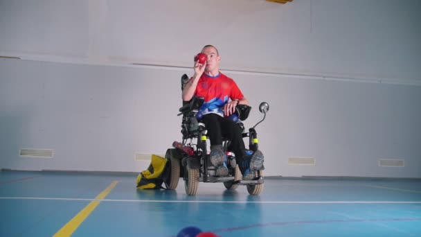 Ein behinderter Mann im Rollstuhl beim Boccia spielen. — Stockvideo