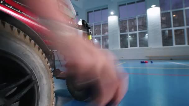 A disabled man in a wheelchair playing boccia. Throwing the ball. Hand in the frame — Stock Video