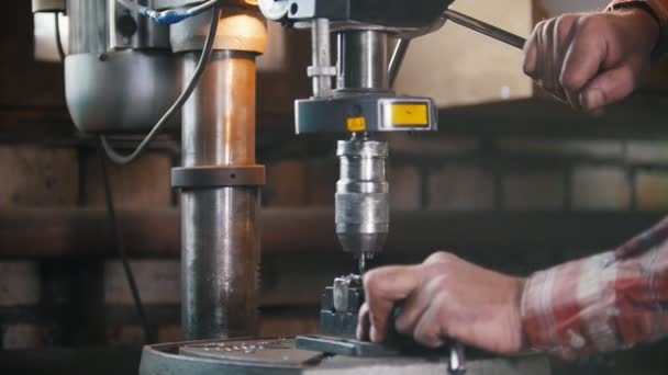 De smid aan het werk met elektrische boor machine, vliegen metalen krullen. Maken van gaten — Stockvideo