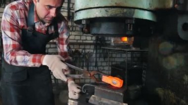 Örs, kırmızı sıcak çelik, yakındaki elektrik çekiç ile iş yerinde demirci kurma