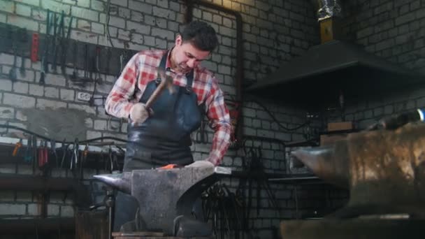 Ferreiro recebendo o detalhe vermelho-quente um formulário com um martelo. Sala de trabalho, bigorna — Vídeo de Stock