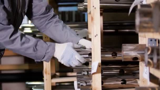 Trabajador pone piezas de acero inoxidable pulido en la fábrica de metal por el hombre en guantes — Vídeo de stock