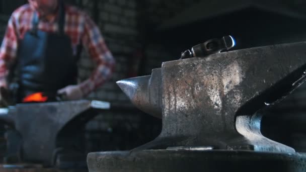 Getting the red-hot detail a form with a hammer. Blacksmith in workroom, anvil — Stock Video