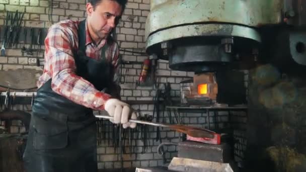 Herrero en el trabajo con el martillo eléctrico cerca del yunque, acero caliente rojo, fabricación — Vídeo de stock