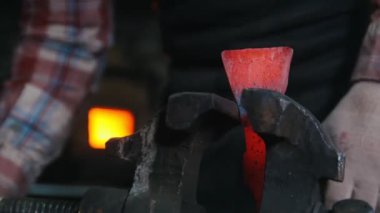 Demirci balta kızgın bir top almak. Ayrıntılı olarak kelepçe