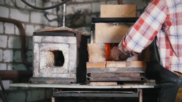 Herrero en el trabajo. Hacer fuego en un horno pequeño — Vídeos de Stock