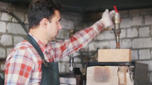 Schmied bei der Arbeit wartet auf die Werkstücke im Ofen — Stockvideo