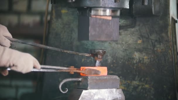 Herrero trabajando con martillo eléctrico en el yunque, haciendo agujeros en acero caliente rojo, artesanía — Vídeo de stock