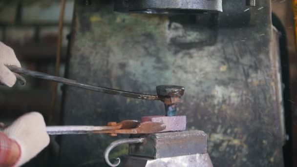 Herrero trabajando con martillo eléctrico en el yunque, hombre trabajador haciendo agujeros en acero caliente rojo, artesanía — Vídeo de stock