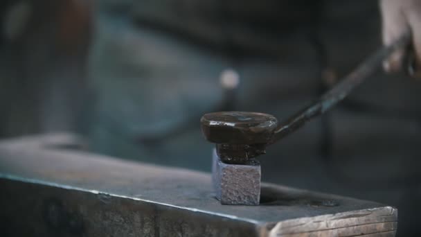 Herrero trabajando con martillo en el yunque, trabajador haciendo agujeros en acero caliente rojo, artesanía — Vídeos de Stock
