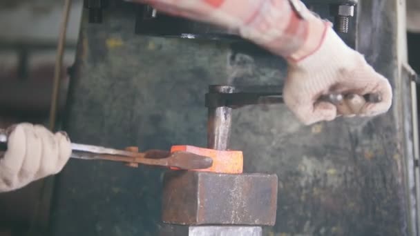 Blacksmith working with hammer on the anvil, man making holes in red hot steel, workpiece of new hammer — Stock Video