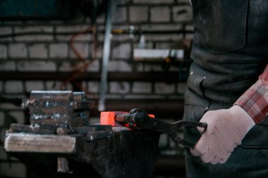 Çalışma alanı demirci. Kırmızı sıcak metal bir forge örs, eldivenlerle çalışan demirci. Portre