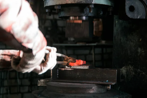 鍛冶屋鍛造にアンビルと電気ハンマー新しい斧の赤いホット金属ワークに取り組んで。アンビルに焦点を当てる — ストック写真