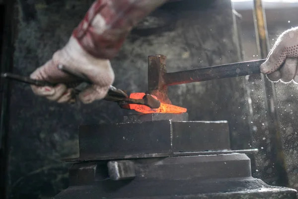 Schmied und Amboss. Schmied arbeitet mit rotem heißem Metall Werkstück der neuen Axt auf dem Amboss in der Schmiede — Stockfoto