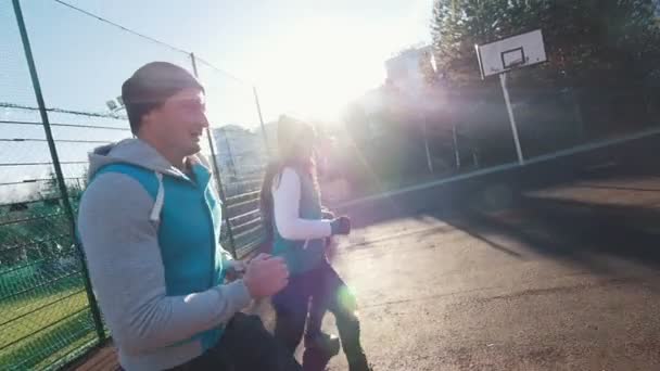 Drei junge Leute laufen auf dem Sportplatz. Seitenansicht. Zeitlupe — Stockvideo