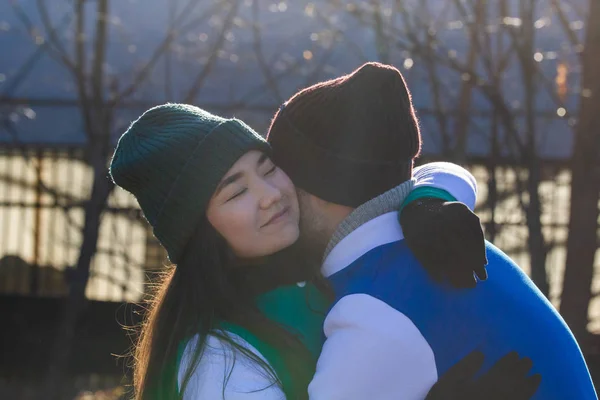 Jeune couple en costumes de sport sur le terrain de sport. S'embrasser — Photo