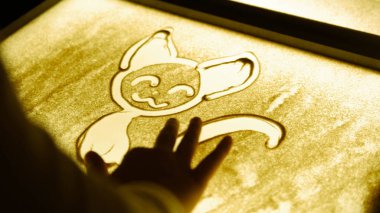 Drawing with a sand on the screen. Drawing a cat clipart