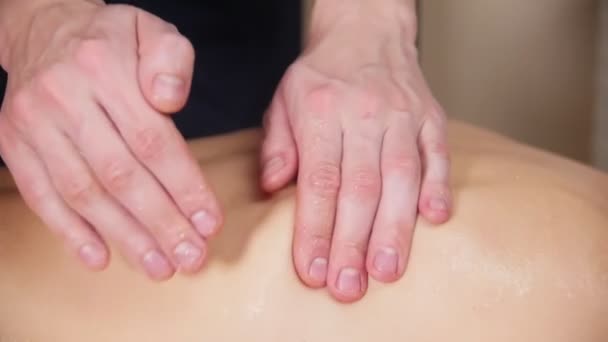 Massage sessie. Jonge vrouw ontvangen van een massage. Masseur taping womans geolied terug — Stockvideo