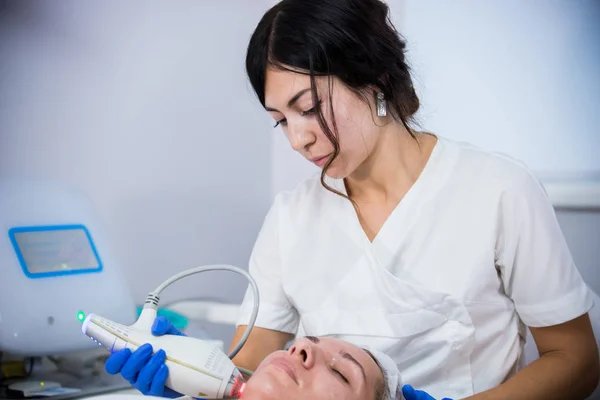 Clínica de Cosmetología. Un cliente tomando el procedimiento. Un cosmetólogo trabajando con una herramienta —  Fotos de Stock