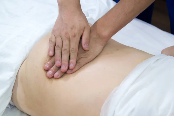 Una mujer que toma un tratamiento de medicina alternativa. Masaje abdominal. De cerca. — Foto de Stock