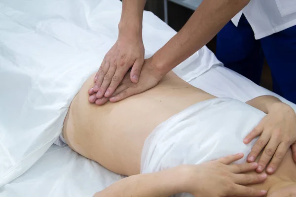 Una mujer que toma un tratamiento de medicina alternativa. Masaje abdominal . — Foto de Stock