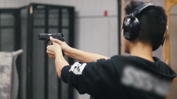 Galería Tiro Joven Sosteniendo Arma Disparando Vista Desde Atrás Movimiento — Vídeo de stock